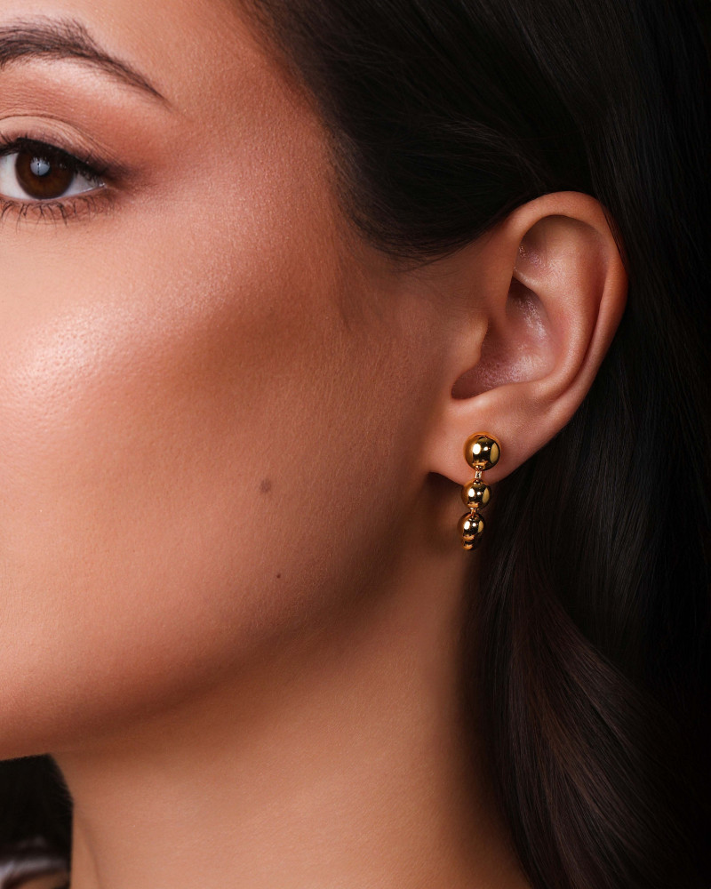 Brinco Palito Curvado Bolas Lisas Banhado a Ouro 18K